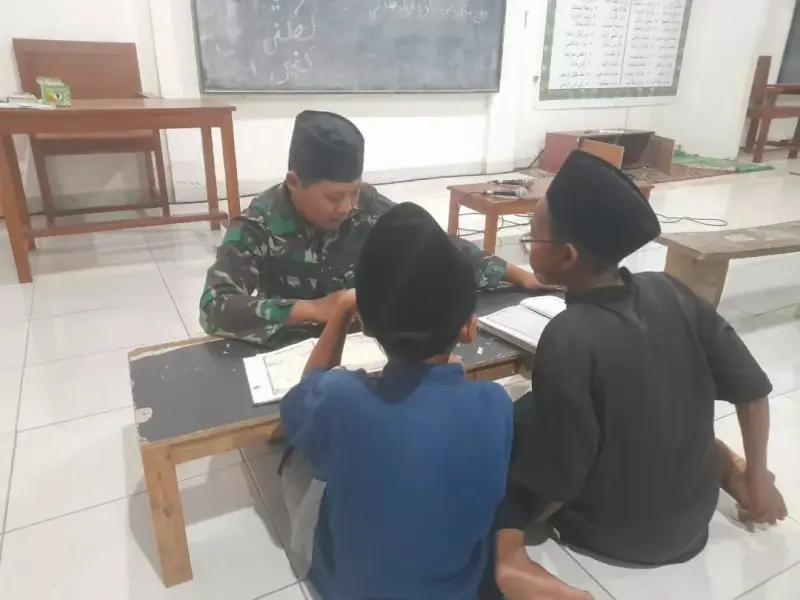 Anggota Satgas TMMD Turut Ajarkan Baca Al Quran Anak-Anak Pojok