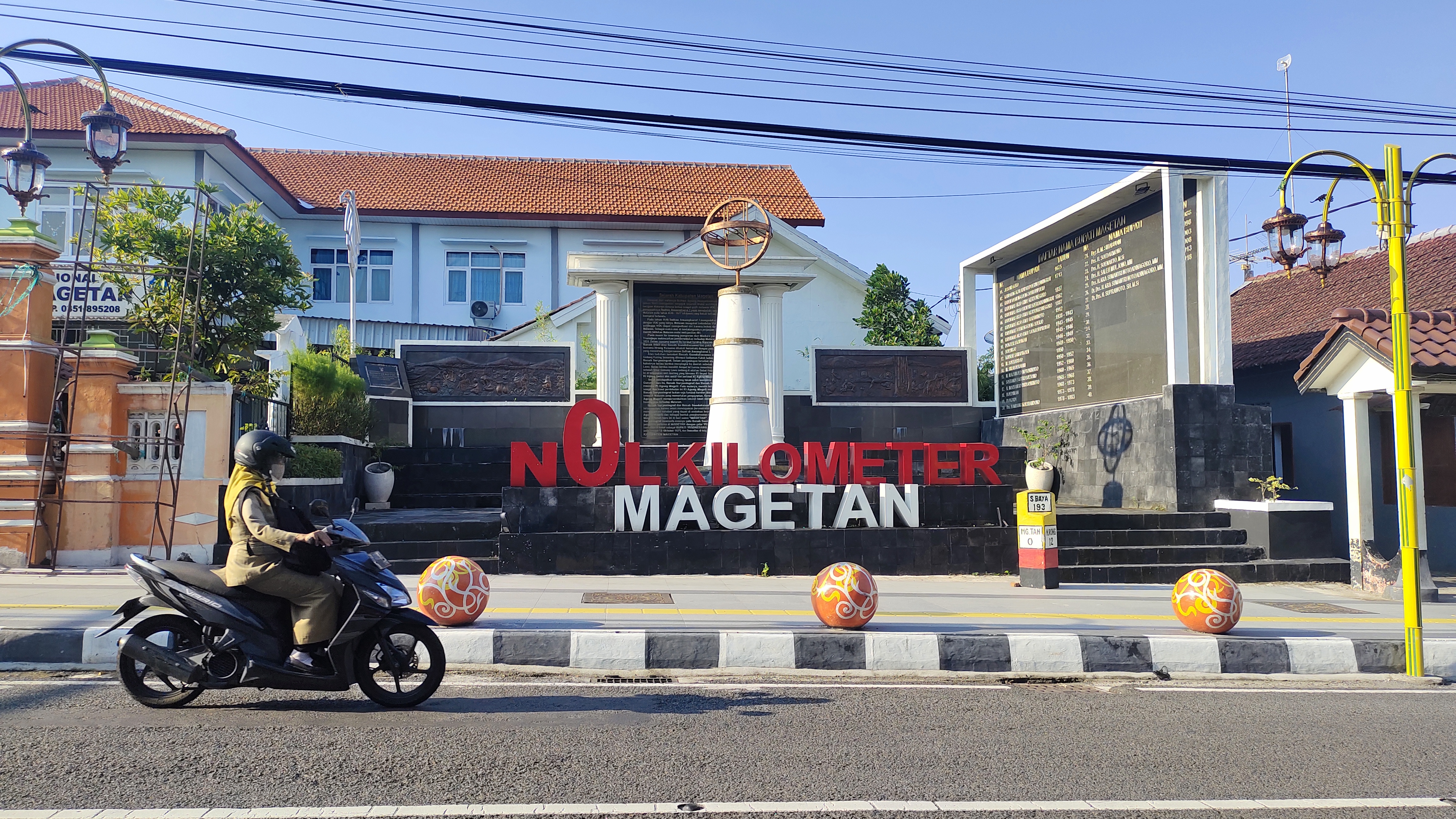Seorang ASN Pemkab Magetan Tengah Melintasi Tugu 0 KM pada Hari Pertama Masuk Kerja Usai Libur  Idul Fitri 1445 H